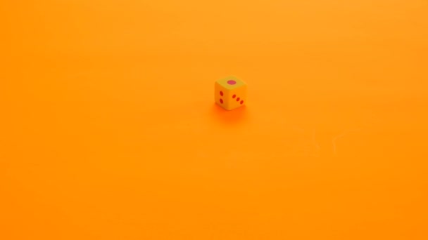 Koncept deskových her. hazardních her. Mnohobarevné kostky pomalu padají na jasně oranžové pozadí - Záběry, video