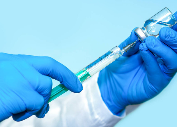 Vacuna en frasco con jeringa sobre fondo azul.El concepto de medicina, salud y ciencia.Vacuna contra el Coronavirus.Copiar el espacio para texto. - Foto, Imagen