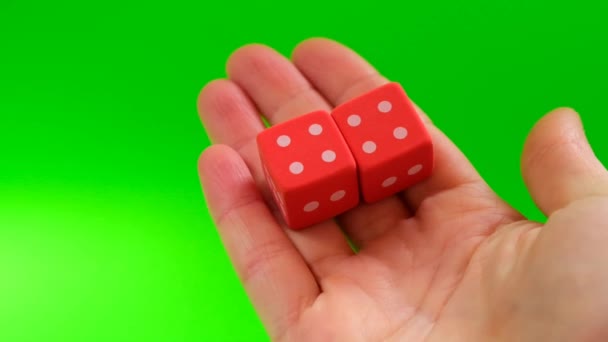 Szerencse és siker koncepció.Szerencsejátékok. Társasjátékok koncepció.Mérkőzés, azonos számok.Piros kockák a kezében a zöld háttér. - Felvétel, videó