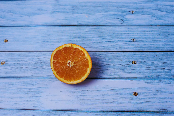 Half orange on light wooden floor with nails, overhead view - Photo, Image