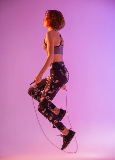 girl on a colorful background is engaged with a skipping rope - Fotografie, Obrázek