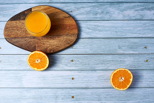 Bir bardak portakal suyu ahşap masada, tahta zeminde çiviler, boş alan, yukarıdan görüş. - Fotoğraf, Görsel