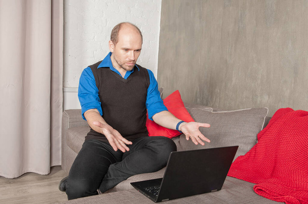 Uomo d'affari infastidito con computer portatile che lavora a casa. Concetto di quarantena e pandemia - Foto, immagini