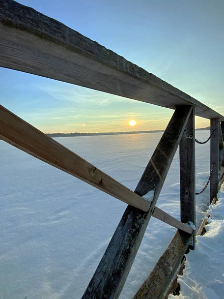 Вид на замерзле озеро Бей поблизу Водави з великою кількістю снігового вигляду оранжевого сонця до заходу сонця, золота година.  - Фото, зображення