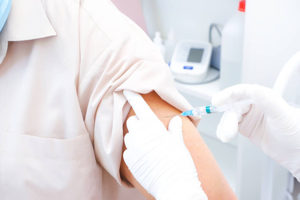 Vaccination of an adult person in a hospital. Healthcare concept, coronavirus vaccine - Valokuva, kuva