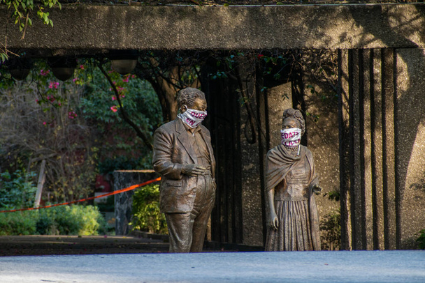 Standbeelden van zitten Frida Kahlo en Diego Rivera dragen gezichtsmaskers - Foto, afbeelding
