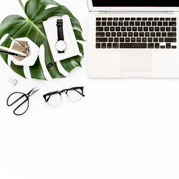 Home office workspace mockup with laptop, tropical leaves Monstera, clipboard, notebook and accessories on white background. Flat lay, top view - Fotó, kép