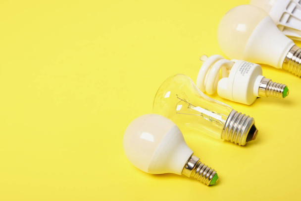 several different bulbs on a yellow background, copy space, trend color, broken and burned out bulbs for recycling - Photo, Image