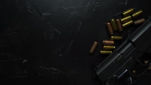 Lőfegyverek és lőszerek a sötét asztalon.  - Felvétel, videó