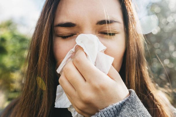 A mulher sopra o nariz num lenço. Um sintoma de uma doença ou alergia - Foto, Imagem