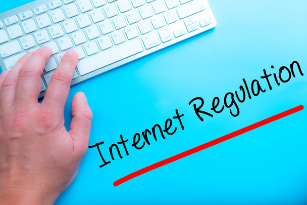 Internet Regulation Sign Working at home with computer man writing. Man hands on the keyboard. Isolated on blue background.   Business concept. Stock Photo - Photo, Image