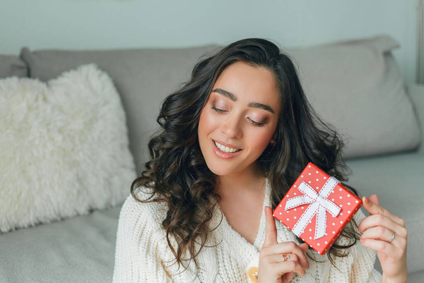 Une jeune femme ouvre une boîte-cadeau rouge. Portrait d'une femme heureuse. Vacances. - Photo, image