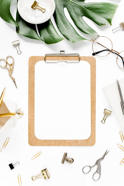Home office workspace mockup with tropical leaves Monstera, clipboard, and accessories on white background. Flat lay, top view - Foto, imagen