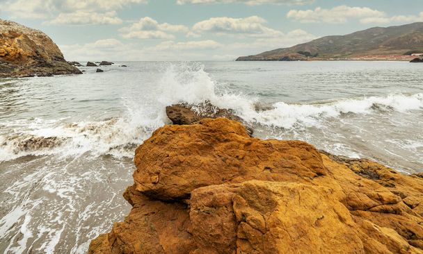 Βραχώδεις σχηματισμοί στο φόντο του ωκεανού στο San Francisco Recreation Area, Rodeo Beach, Καλιφόρνια, ΗΠΑ. Παραλιακή, όμορφο τοπίο, ακτή της Καλιφόρνια. - Φωτογραφία, εικόνα