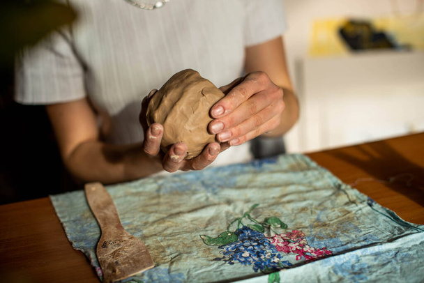 陶器だ。彼女の手に文字列を持つ女の子は、粘土の上の層を切ります.セラミック製品のモデリングのプロセス. - 写真・画像