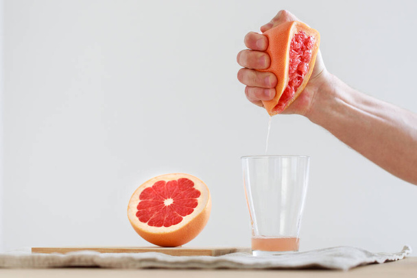 Kézzel facsart grépfrútlé. A C-vitamin létfontosságú az immunrendszer egészségének megőrzéséhez. Hasznos a megfázáshoz - Fotó, kép