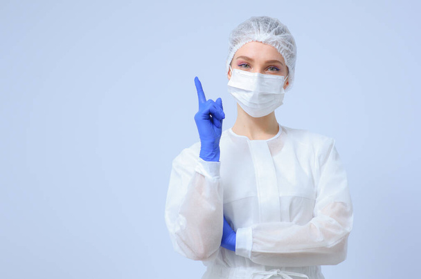 Portrait of a female doctor or nurse wearing medical cap and face mask - Foto, Imagem