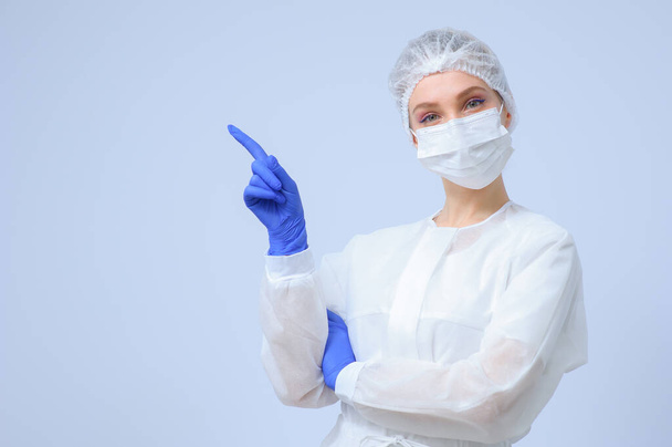 Portrait of a female doctor or nurse wearing medical cap and face mask - Foto, afbeelding