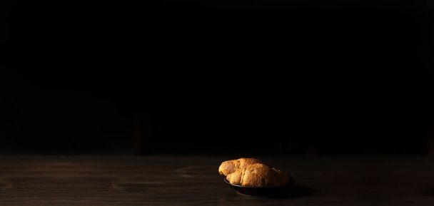 Croissants em uma chapa no escuro. Minimalismo. Café da manhã - Foto, Imagem