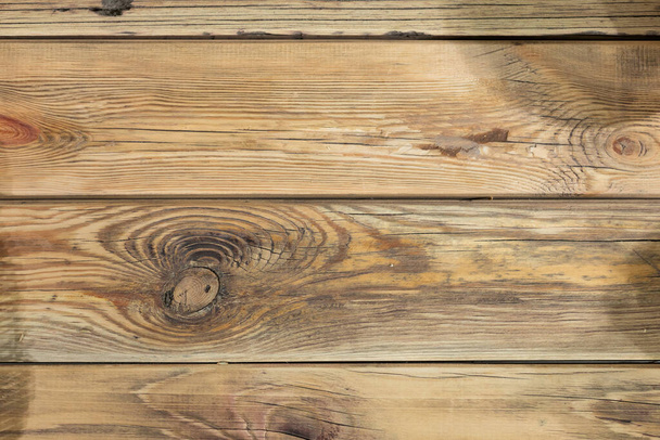 Old wooden boards with cracks and a visible structure as well as gulp and knots. Alder board as a background for various natural designs and compositions. - Foto, Imagen