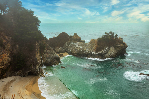 Big Sur 'daki McWay Falls, California' nın Pasifik sahillerinde güzel bir manzara, hafif sis. Kartpostallar, turizm rehberi ve seyahat rehberi için konsept resim. - Fotoğraf, Görsel