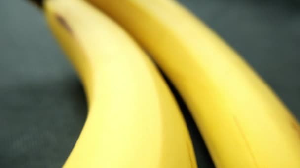 Banany izolowane na stole z ciemnym obrusem - Materiał filmowy, wideo