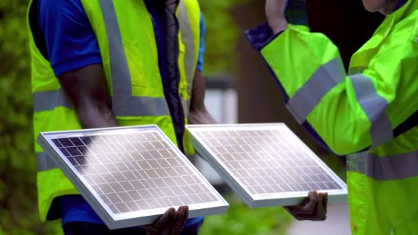 pracownik fabryki inżynier ludzie pokazując i sprawdzając panelu ogniw słonecznych dla zrównoważonej technologii z kombinezonu roboczego i kasku. Koncepcja instalacji konstrukcji panelu fotowoltaicznego energii odnawialnej. - Materiał filmowy, wideo