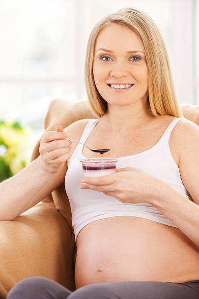 Pregnant woman eating yogurt - Фото, зображення