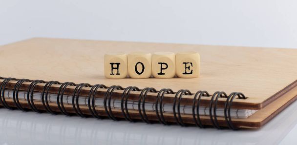 palavra esperança feita com letras em blocos de madeira no bloco de notas de madeira - Foto, Imagem