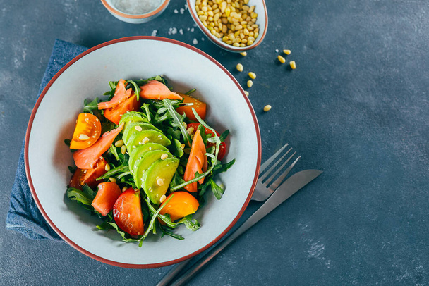 Ensalada vegana saludable con tomate, rúcula, salmón y sésamo. Menú de dieta. Vista superior, espacio de copia. - Foto, Imagen