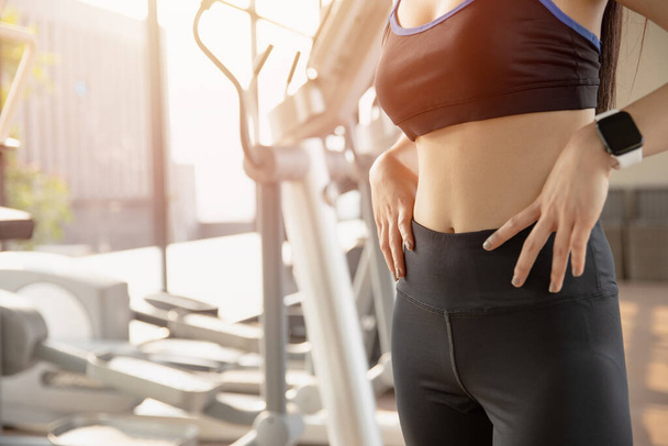 Mujeres con abdomen delgado Los músculos abdominales en forma y firme en ropa deportiva en el fondo del club deportivo gimnasio - Foto, imagen