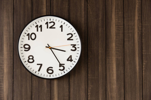 Time Clock hang on dark wooden wall background space for text - Fotó, kép