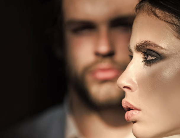 Girl with makeup, eyeshadows, blush, foundation. Woman face profile with blurred man on background. Couple of fashion models. - Фото, зображення