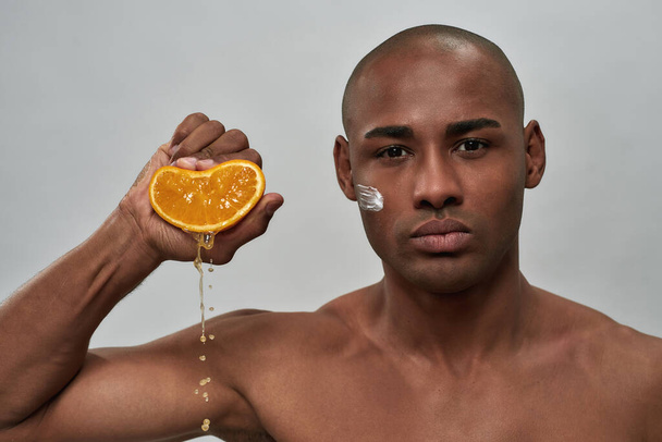 Juice falling from an orange in mixed-race male hand - Foto, Imagem