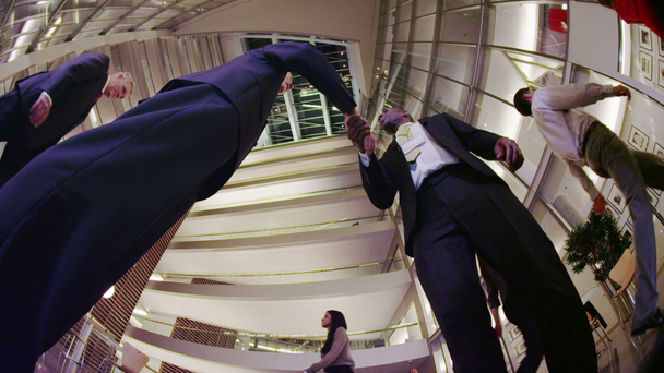 Geschäftsleute treffen sich zum Händeschütteln in der Lobby eines modernen Bürogebäudes - Filmmaterial, Video