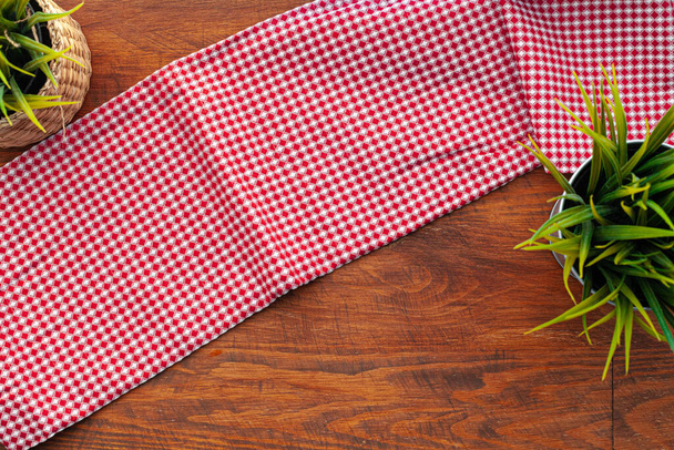 Κόκκινη καρό πετσέτα ή τραπεζομάντιλο σε ξύλινο τραπέζι - Φωτογραφία, εικόνα