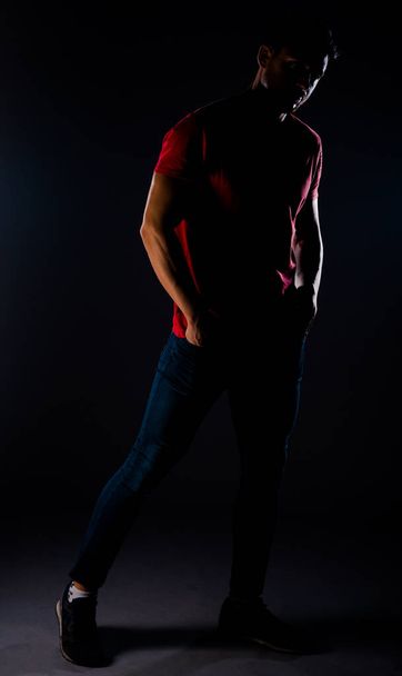 Elegante hombre de moda con jeans azules elegantes, camiseta roja y zapatillas de deporte - Foto, imagen