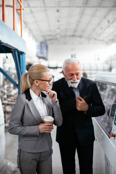 Factory managers in inspection of manufacturing. Businesswoman and businessman in industrial environment. - Foto, imagen