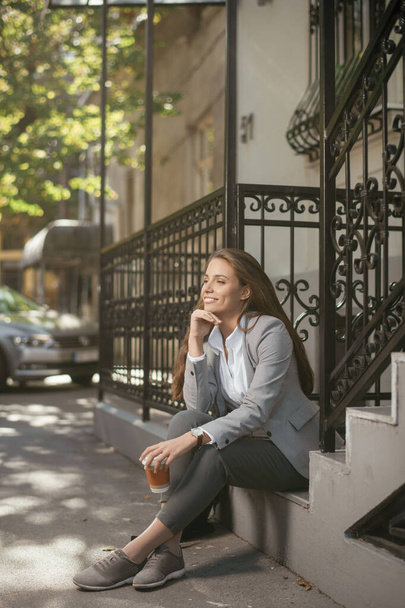 jovem bela mulher sentada na rua e beber café  - Foto, Imagem