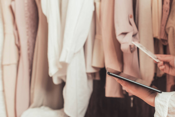 Female entrepreneur holding tablet while doing inventory in her trendy clothing shop - Φωτογραφία, εικόνα