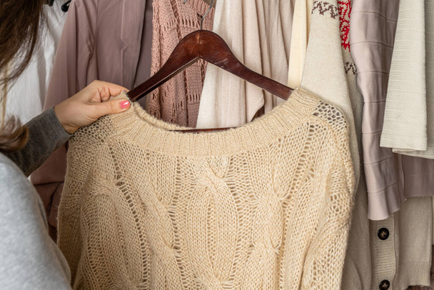 Woman shopper, customer choosing clothes. Assortment of female modern summer and autumn clothing in garment store. Shopping. - Zdjęcie, obraz