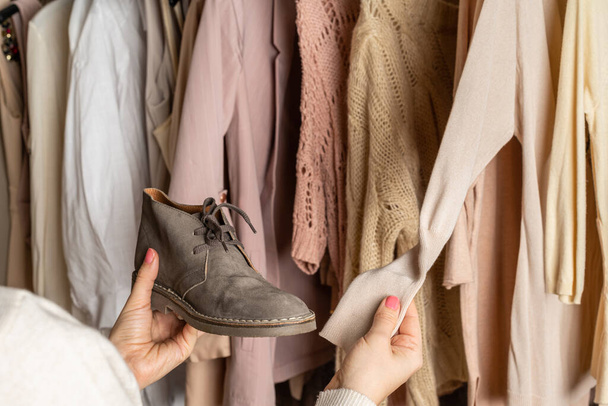 Woman choosing boots (shoes) and clothes in home cupboard. Season concept - Valokuva, kuva
