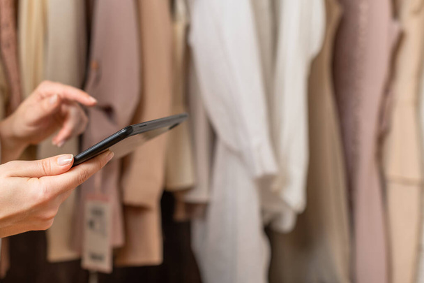 Female entrepreneur holding tablet while doing inventory in her trendy clothing shop - Foto, Bild