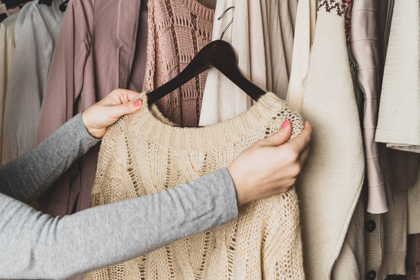 Woman choosing woolen sweater in home cupboard. Season concept - 写真・画像