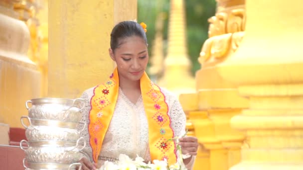 Γυναίκες από τη Μιανμάρ κρατούσαν λουλούδια σε ναό. Νεαρά κορίτσια της Νοτιοανατολικής Ασίας με παραδοσιακό φόρεμα που επισκέπτονται ναό Buddihist. - Πλάνα, βίντεο