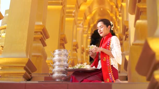 Οι γυναίκες της Μιανμάρ έχουν λουλούδια στο χέρι. Νεαρά κορίτσια της Νοτιοανατολικής Ασίας με παραδοσιακό φόρεμα που επισκέπτονται ναό Buddihist - Πλάνα, βίντεο