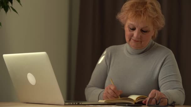 Крупним планом зморшкуваті чоловічі руки пишуть інформацію. Стара зріла жінка працює в офісі, використовуючи комп'ютер, нотатки про почерк
 - Кадри, відео