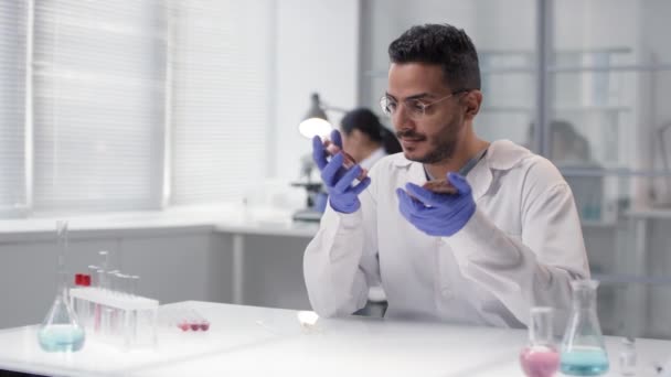 Medium slowmo portrait of young middle eastern scientist examining cultured and regular meat samples then looking at camera smiling - Footage, Video