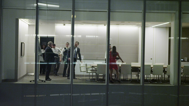 Diverse business team in late night boardroom meeting in contemporary office - Footage, Video