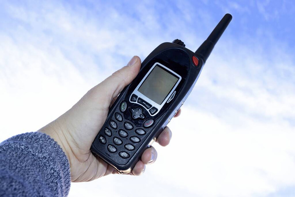 Usando um walkie talkie, equipamentos de telecomunicações contra o céu azul - Foto, Imagem